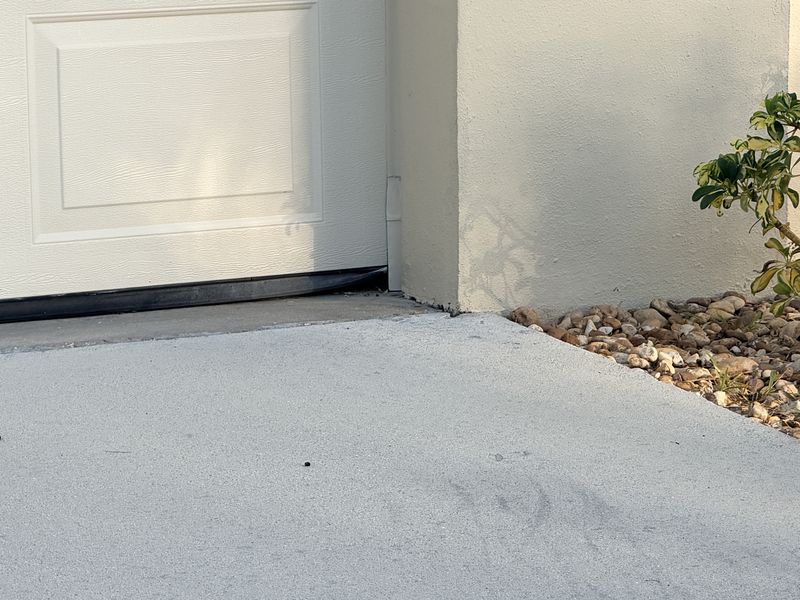 Roof rat entry gap at garage door corner, where the bottom seal meets the jamb